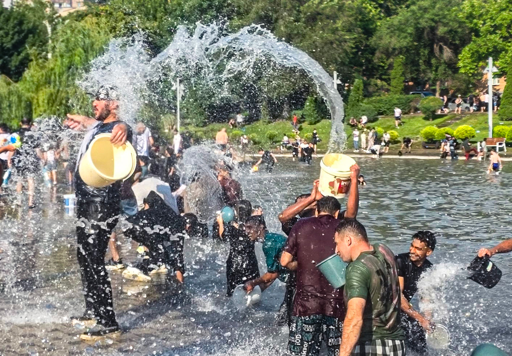 Candid moment of people laughing and splashing each other during Vardavar in Yerevan